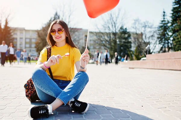 Ung tonårsflicka som sitter på gatorna i staden med lollipop och — Stockfoto