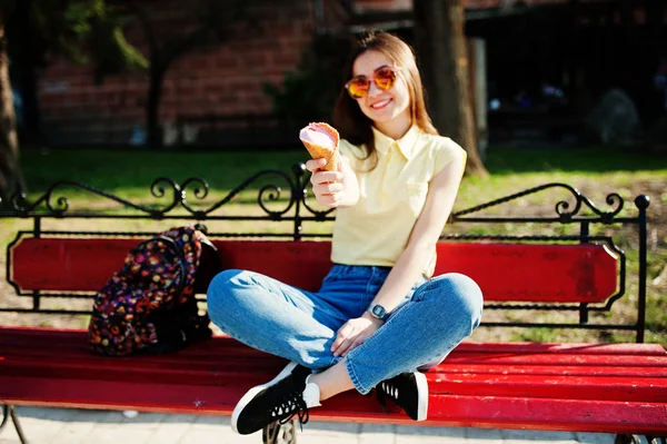 Jovem adolescente sentado no banco com um sorvete nas mãos, wea — Fotografia de Stock