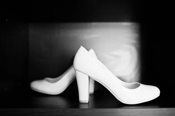 Белые свадебные туфли невесты на деревянном фоне . — стоковое фото