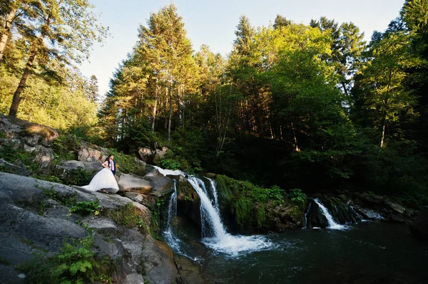 Casal encantador contra a cachoeira no pôr do sol em Cárpatos — Fotografia de Stock