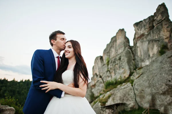 Hermosa pareja de boda contra las rocas de la fortaleza Tustan en Carpath —  Fotos de Stock