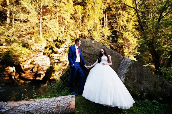 Casamento encantador casal contra rio com pedras em Carpathian mo — Fotografia de Stock