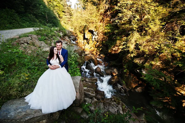 Härliga bröllop par mot floden med stenar på Karpaterna mo — Stockfoto