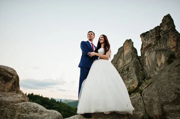 Hermosa pareja de boda contra las rocas de la fortaleza Tustan en Carpath —  Fotos de Stock