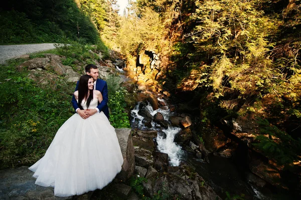 Preciosa pareja de boda contra el río con piedras en Carpathian mo —  Fotos de Stock