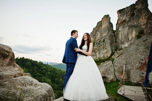 Lovely wedding couple against rocks of fortess Tustan at Carpath — Stock Photo, Image