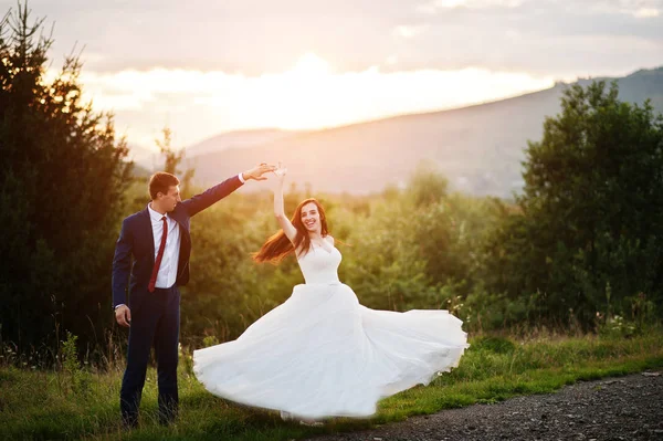 Beau couple de mariage contre le coucher du soleil dans les Carpates . — Photo