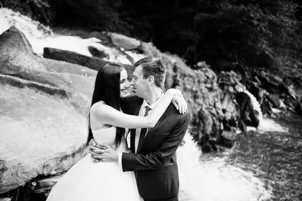 Casal encantador contra a cachoeira no pôr do sol em Cárpatos — Fotografia de Stock