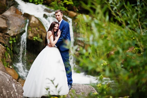 Casal encantador contra a cachoeira no pôr do sol em Cárpatos — Fotografia de Stock