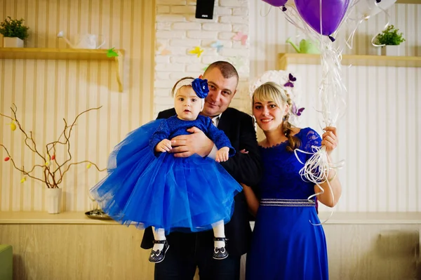 Menina bonito pequeno no vestido azul nas mãos do pai e mothe — Fotografia de Stock