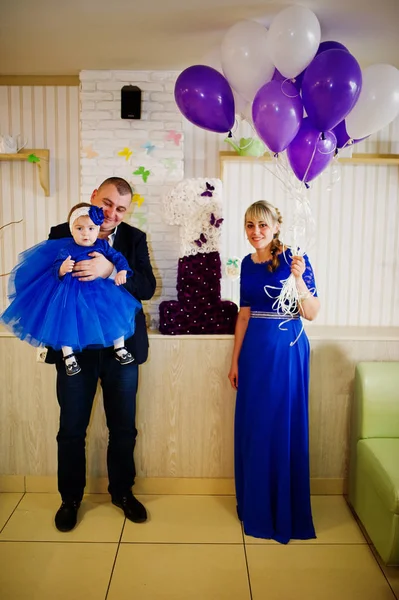 Menina bonito pequeno no vestido azul nas mãos do pai e mothe — Fotografia de Stock