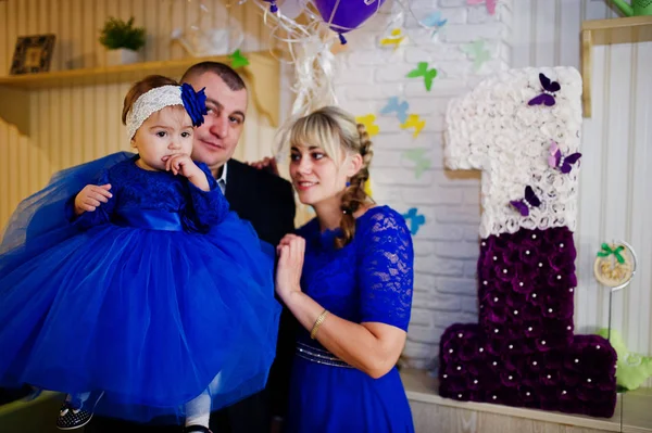 Χαριτωμένο μωρό κοριτσάκι στο μπλε φόρεμα στα χέρια του πατέρα και mothe — Φωτογραφία Αρχείου