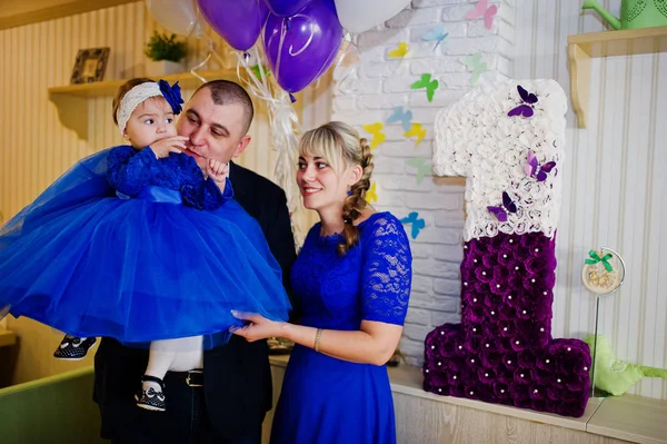 Menina bonito pequeno no vestido azul nas mãos do pai e mothe — Fotografia de Stock