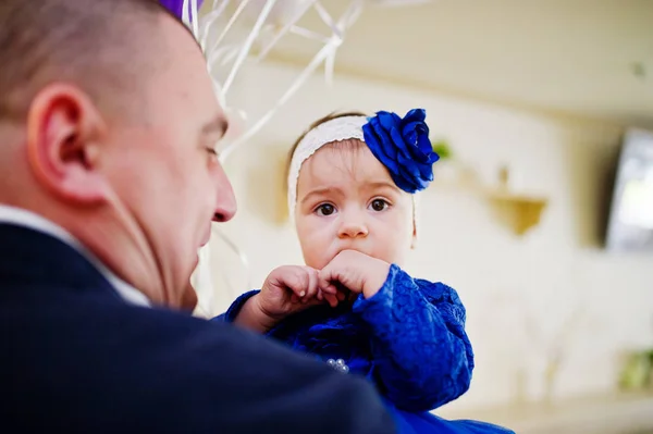 Söt liten baby flicka i blå klänning på händerna på far. — Stockfoto