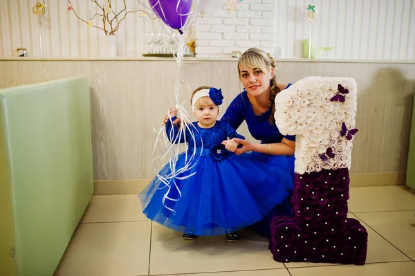 Menina bonito pequeno no vestido azul perto de 1 ano número de aniversário — Fotografia de Stock