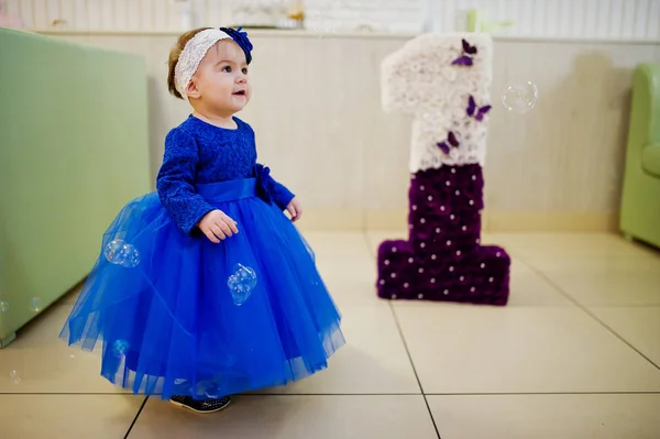 Roztomilá malá holčička v modré šaty hrát s mýdlovými bublinami. 1 ye — Stock fotografie