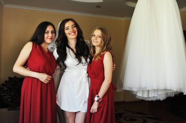 Mutlu neşeli esmer gelin odasına iki gelinle giyiyor