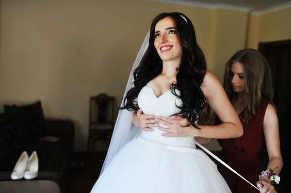 Щаслива весела брюнетка наречена носить у своїй кімнаті з двома нареченими — стокове фото