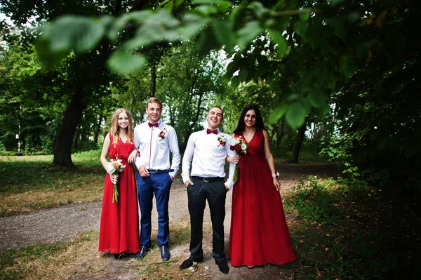 Brautjungfern in roten Kleidern mit Trauzeugen oder Trauzeugen bei der Hochzeit — Stockfoto