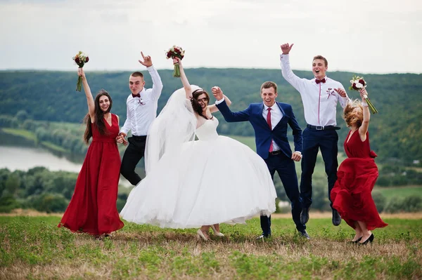 Matrimonio coppia con damigelle e migliori uomini a piedi all'aperto . — Foto Stock