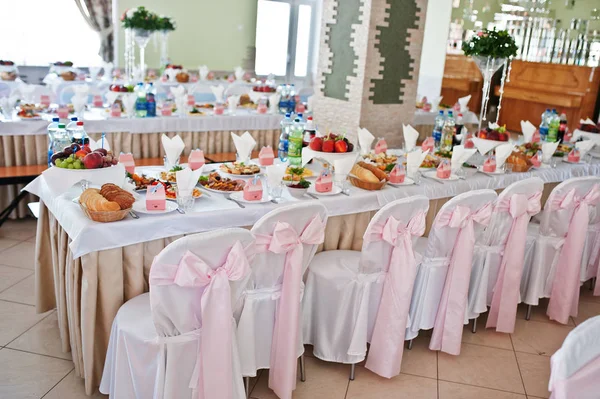 Stühle mit rosa Schleife im Hochzeitssaal. — Stockfoto