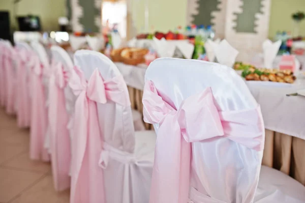 Chairs with pink bow at wedding hall. — Stock Photo, Image