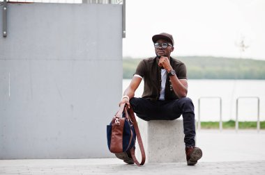 Şık Afro-Amerikan erkek giyimi sunglas üzerinde oturma portre