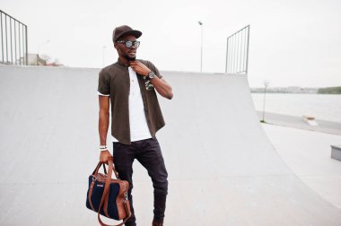 Şık Afro-Amerikan erkek giyimi sunglas üzerinde oturma portre