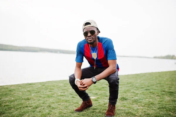 Şık Afro-Amerikan çocuk futbol cap adlı aşınma oturdu t-shirt bir