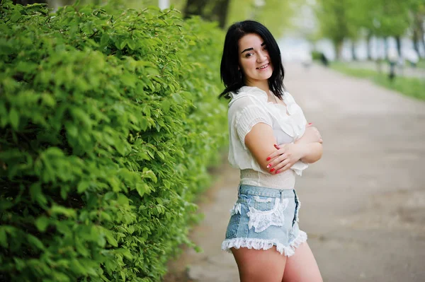 Retrato de menina morena sexy em shorts jeans femininos e branco — Fotografia de Stock