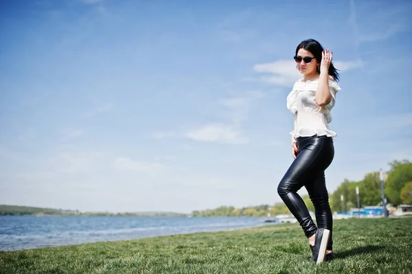 Menina morena em calças de couro das mulheres e blusa branca, sol — Fotografia de Stock