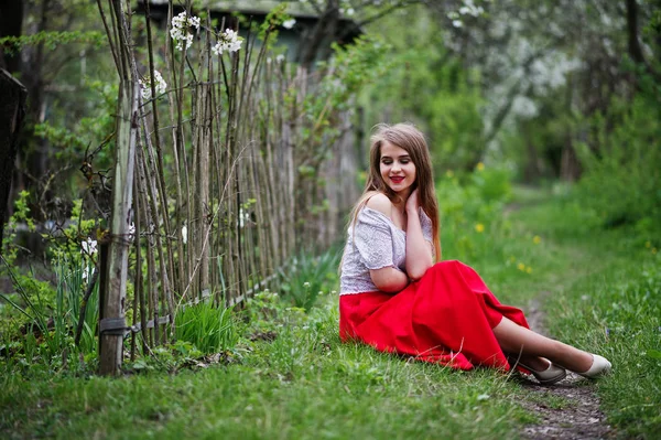 Retrato de sentada hermosa chica con labios rojos en la floración de primavera —  Fotos de Stock