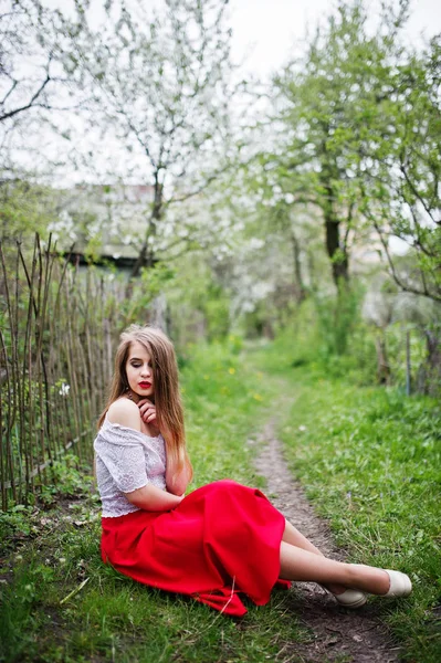 Portrait de belle fille assise avec des lèvres rouges au printemps bloss — Photo
