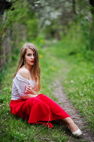 Portrait de belle fille assise avec des lèvres rouges au printemps bloss — Photo