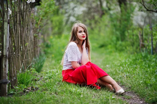 Portrait de belle fille assise avec des lèvres rouges au printemps bloss — Photo
