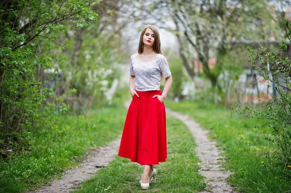Портрет красивой девушки с красными губами в весеннем цветущем саду — стоковое фото