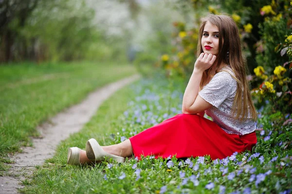 Portrait of sitiing beautiful girl with red lips at spring bloss — Stock Photo, Image