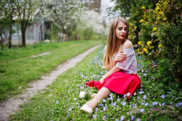 Portret de sitiing fată frumoasă cu buze roșii la floarea primăverii — Fotografie, imagine de stoc