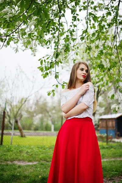 Портрет красивой девушки с красными губами в весеннем цветущем саду — стоковое фото