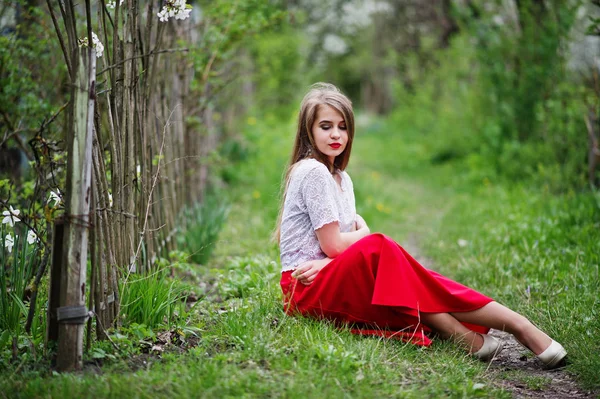 Portrait of sitting beautiful girl with red lips at spring bloss — Stock Photo, Image