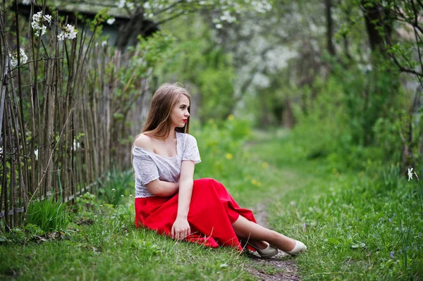 Ritratto di bella ragazza seduta con labbra rosse a fiore di primavera — Foto Stock