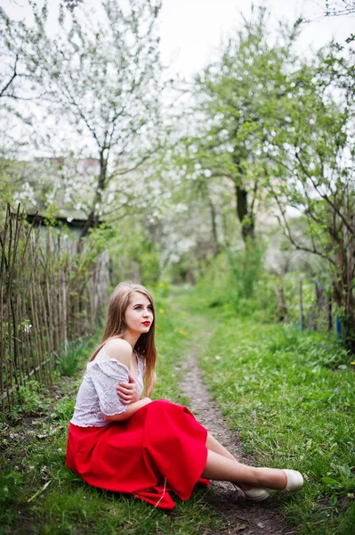 Портрет сидящей красивой девушки с красными губами на весеннем блеске — стоковое фото
