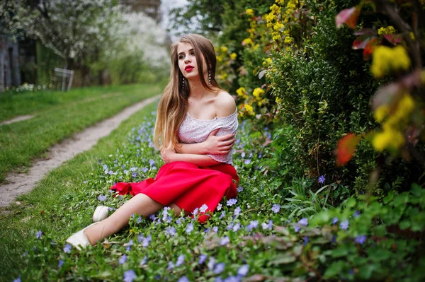 Retrato de sitiing menina bonita com lábios vermelhos na flor da primavera — Fotografia de Stock