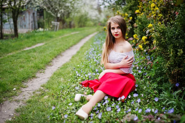 Retrato de sitiing menina bonita com lábios vermelhos na flor da primavera — Fotografia de Stock