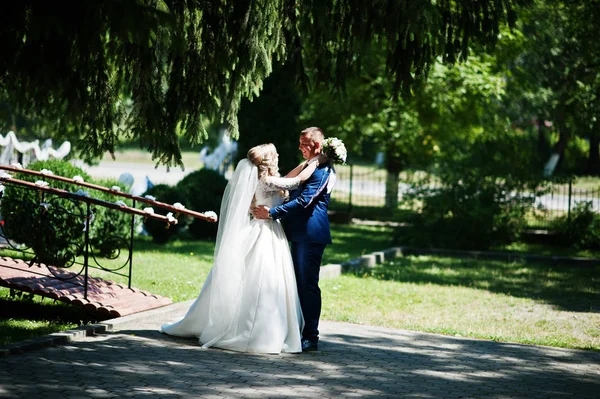 Buon matrimonio coppia innamorata vicino a piccolo ponte a parco su soleggiato — Foto Stock