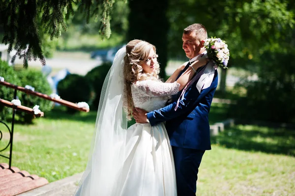 Glückliches Hochzeitspaar verliebt nahe kleiner Brücke im Park bei sonnigem Wetter — Stockfoto