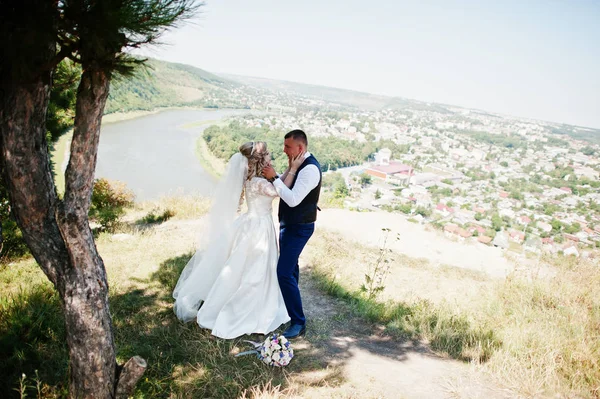 Glückliches Hochzeitspaar verliebt an sonnigem Tag gegen Klippenwitz — Stockfoto