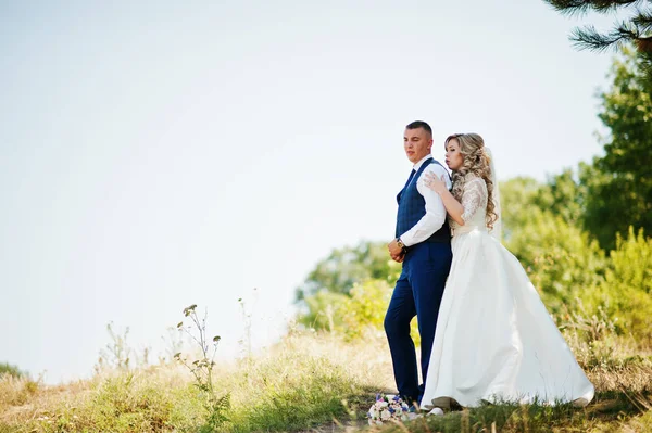 Happy wedding couple in love on sunny day stay near trees. — Stock Photo, Image