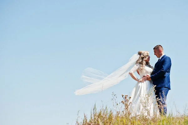 幸福的新婚夫妇在爱在阳光灿烂的日子呆在蔚蓝色的天空. — 图库照片