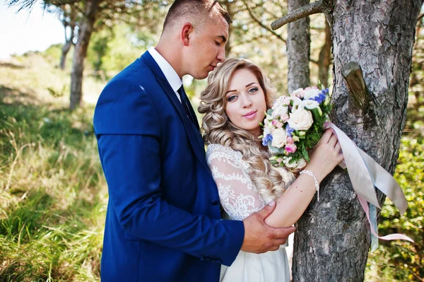 Casal de casamento feliz no amor no dia ensolarado ficar perto de árvores . — Fotografia de Stock